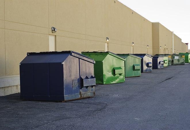 a pile of demolition waste sits beside a dumpster in a parking lot in Loomis